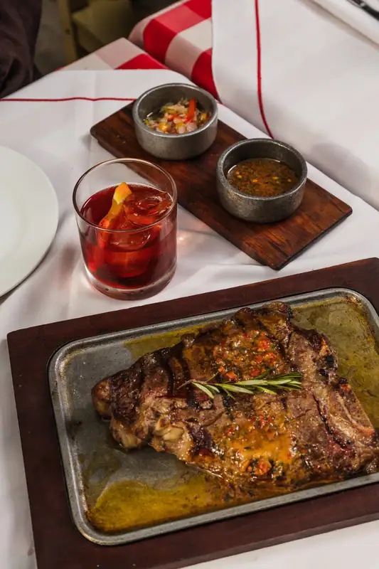 Bife a la parrilla servido en tabla con salsas en El Gran Paraíso, La Boca