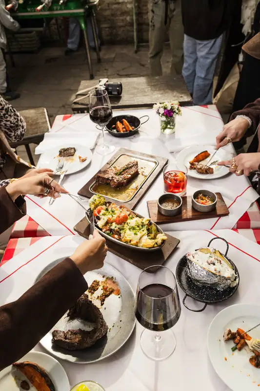 Mesa larga con platos para compartir en El Gran Paraíso, La Boca